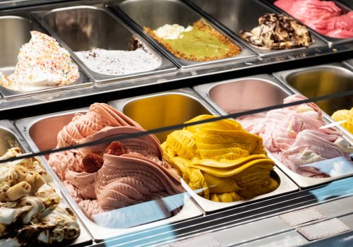 Different types of ice cream in containers on a store close up